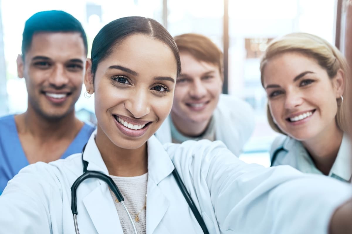 Pflegeteam macht Selfie - zufriedene Mitarbeiter im Gesundheitswesen